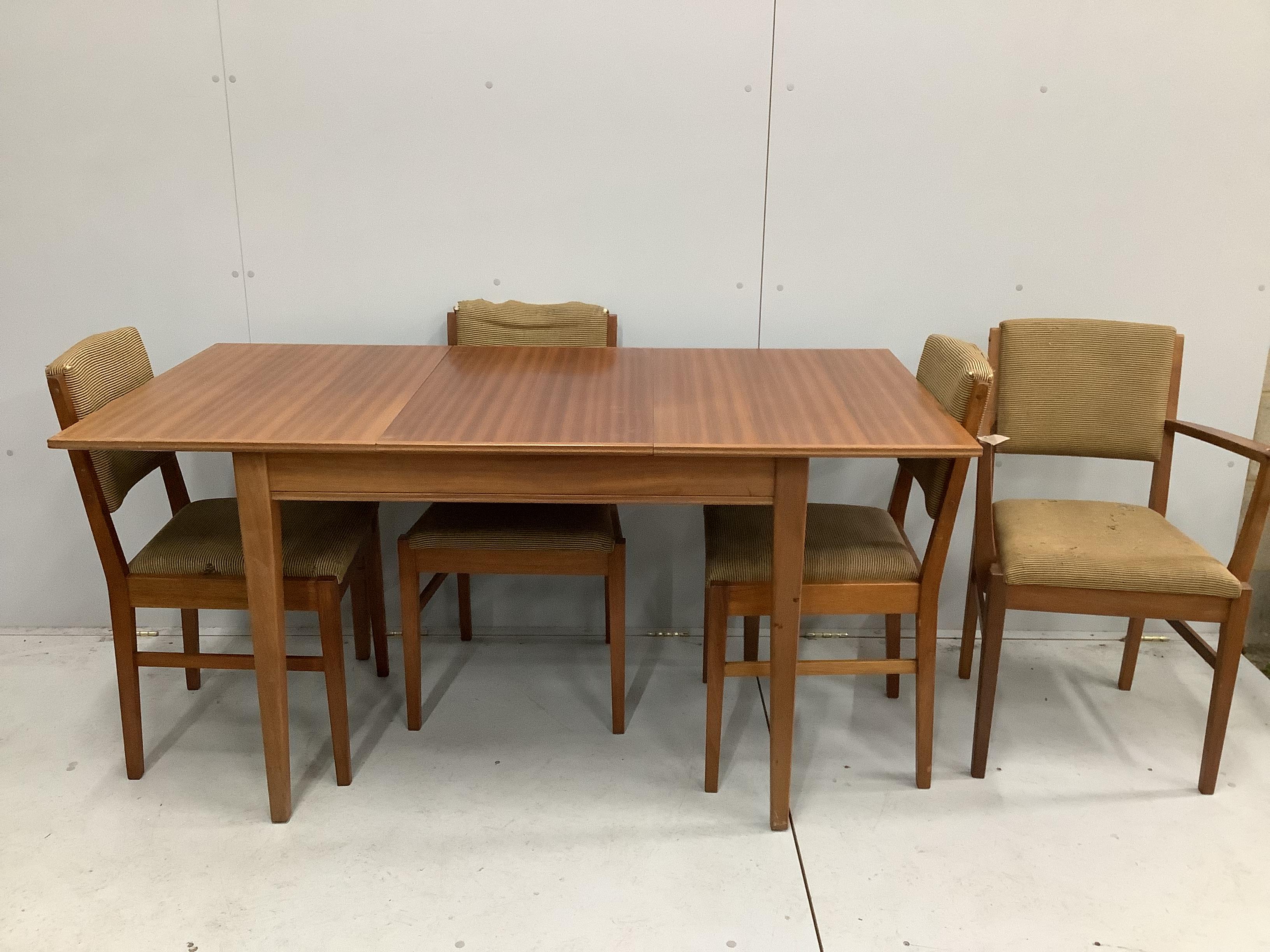 A Gordon Russell Broadway, mid century teak extending dining table, 153cm extended, width 78cm, height 77cm and five chairs, one with arms.